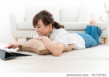 Asian woman using tablet pc at home Asian woman using tablet pc at home 95716762