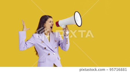 Emotional female activist with megaphone makes loud message on yellow background. 95716881