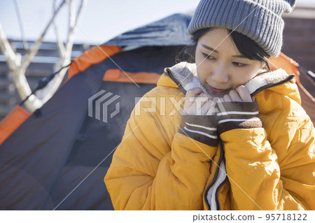 冬令營形象 一個在營地抵禦寒冷的年輕女子 冬令營形象 一個在營地抵禦寒冷的年輕女子 95718122