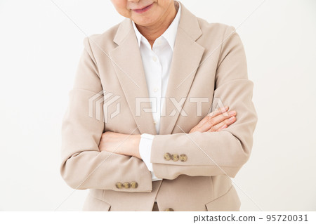 Elegant Middle Aged Woman With Her Arms Crossed Against White