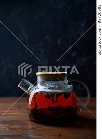 Teapot of tea standing on wooden table 95720998