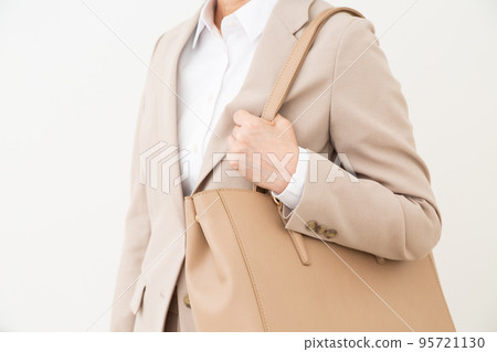 一位身著米色西裝和白色 Y 卹,手拿包的中年婦女 一位身著米色西裝和白色 Y 卹,手拿包的中年婦女 95721130