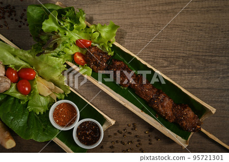 Bamboo barrel plate with grilled meat skewers served fresh vegetable on wooden background Bamboo barrel plate with grilled meat skewers served fresh vegetable on wooden background 95721301
