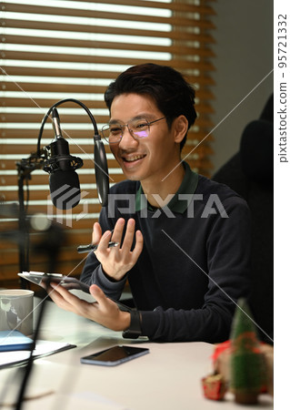 Smiling young asian man recording conversation for channel to recording podcast in small home studio 95721332