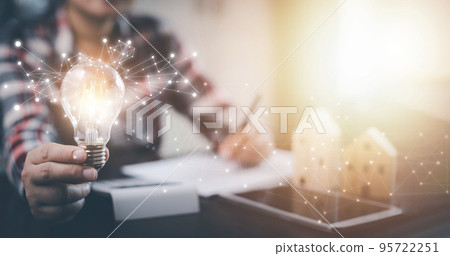 Businesswoman hand holding light bulb with icons and working on the desk, Creativity and innovation are keys to success.Concept of new idea and innovation with energy and power , working at home, Businesswoman hand holding light bulb with icons and working on the desk, Creativity and innovation are keys to success.Concept of new idea and innovation with energy and power , working at home, 95722251