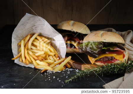 burgers and fries on a wooden background 95723595