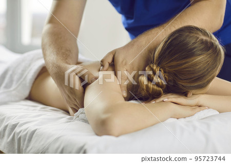 Male masseur massage client in wellness clinic Male masseur massage client in wellness clinic 95723744