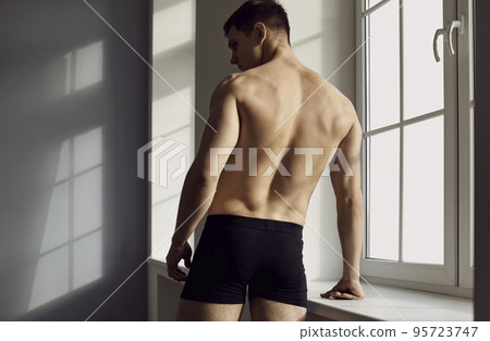 Young man in black underwear, with a beautiful, athletic body posing in the studio 95723747