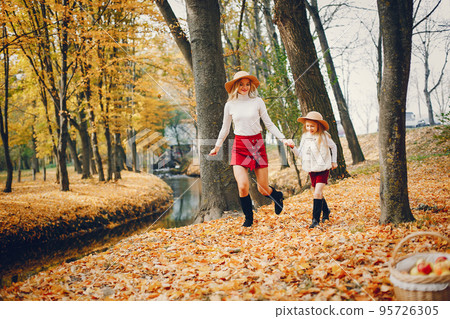 Fashionable mother with daughter. Family in a autumn park. Fashionable mother with daughter. Family in a autumn park. 95726305