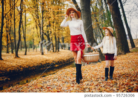 Fashionable mother with daughter. Family in a autumn park. Fashionable mother with daughter. Family in a autumn park. 95726306