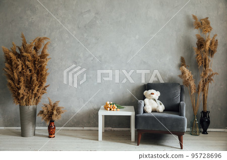 room with an armchair and dried flowers 95728696