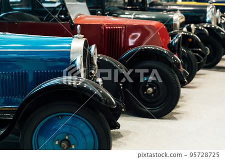 a lot of vintage cars are in the garage for the trip 95728725