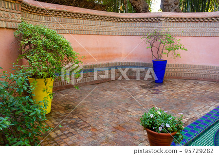 Entrance place with fountain and potted plants with colorful pots  in Majorelle garden 95729282