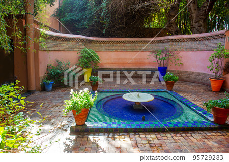Entrance place with fountain and potted plants with colorful pots  in Majorelle garden 95729283