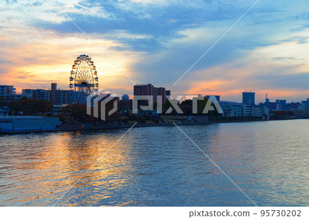 View of the new Ferris wheel at dusk from Arakawa Amusement Park from Odaibashi Bridge 95730202