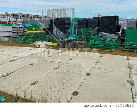 A large outdoor warehouse at a construction site, a warehouse for industrial equipment and materials in boxes at an open-air storage site 95730636
