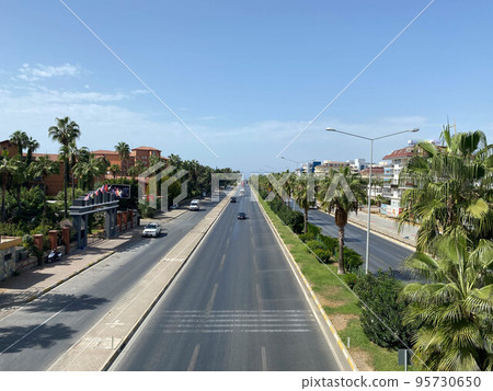 Large wide multi-lane highway road with palm trees on the sides in a warm tropical country southern resort 95730650