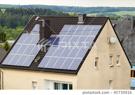 Renewable clean green energy saving efficient solar panels on suburban house roof. 95730916