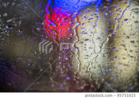 Abstract colorful background of glass surface with water drops and blurred city lights. Abstract colorful background of glass surface with water drops and blurred city lights. 95731015