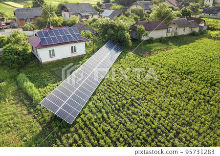 Aerial view of a house with blue solar panels for clean energy. Aerial view of a house with blue solar panels for clean energy. 95731283