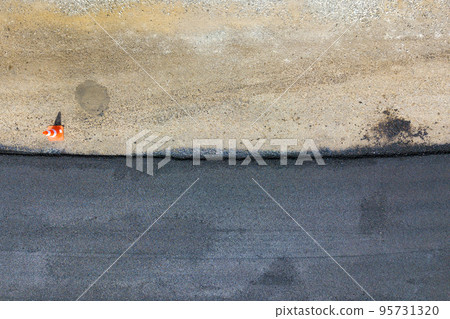 Aerial view of new road construction with newly layed black asphalt lane. Aerial view of new road construction with newly layed black asphalt lane. 95731320