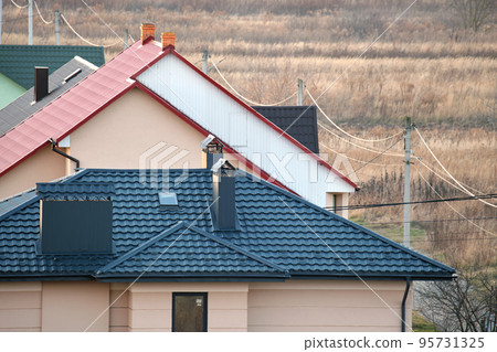 Residential houses with roof tops covered with metallic and ceramic shingles in rural suburban area Residential houses with roof tops covered with metallic and ceramic shingles in rural suburban area 95731325
