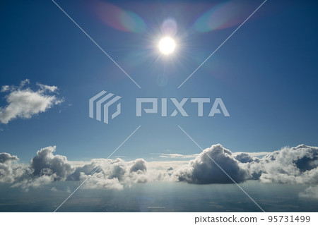 Aerial view from airplane window at high altitude of earth covered with puffy cumulus clouds forming before rainstorm Aerial view from airplane window at high altitude of earth covered with puffy cumulus clouds forming before rainstorm 95731499
