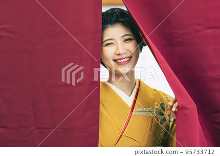 A woman in a kimono showing her face from the curtain A woman in a kimono showing her face from the curtain 95733712