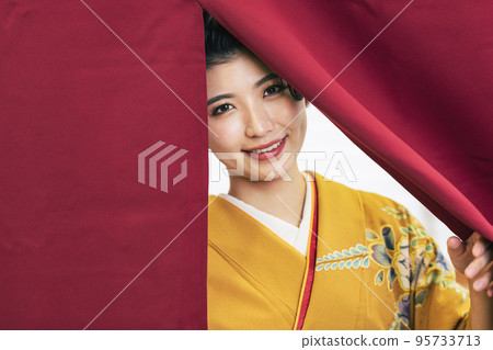 A woman in a kimono showing her face from the curtain A woman in a kimono showing her face from the curtain 95733713