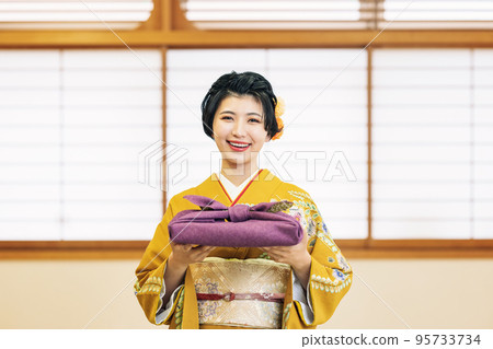 A woman in a kimono with a gift 95733734