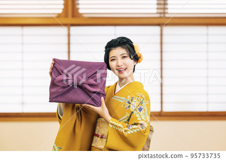 一個穿著和服的女人帶著禮物 95733735