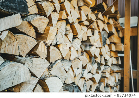 Stacked dry split wood for heating in a northern cold climate. 95734074