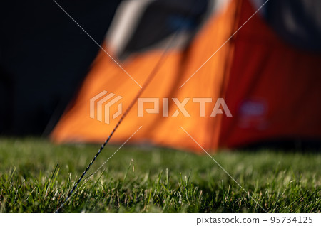 Selective focus on tent support rope leading up to the canvas to secure in-place 95734125