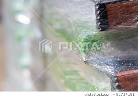 Selective focus on cellophane shrink wrap on pallets of goods for transport.  95734191