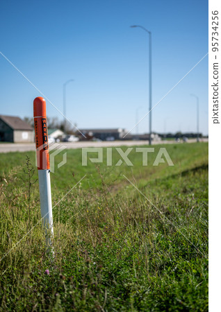 Marker post for underground internet optics line along a road ditch. Marker post for underground internet optics line along a road ditch. 95734256