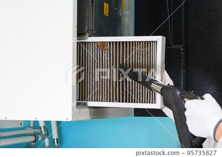 hvac filter replacement home central air system. servicemen changing filter in furnace. 95735827
