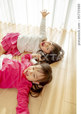 Sisters playing in the living room 95735980