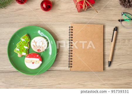 Blank notebook, black, Christmas cookies and pen on wood table, Top view and copy space. Xmas, Happy New Year, Goals, Resolution, To do list, Strategy and Plan concept Blank notebook, black, Christmas cookies and pen on wood table, Top view and copy space. Xmas, Happy New Year, Goals, Resolution, To do list, Strategy and Plan concept 95739331