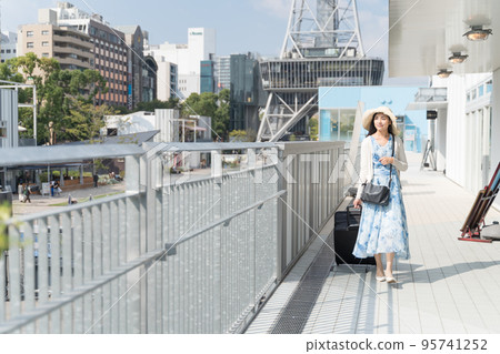 A young woman pulling a suitcase and sightseeing in Nagoya 95741252