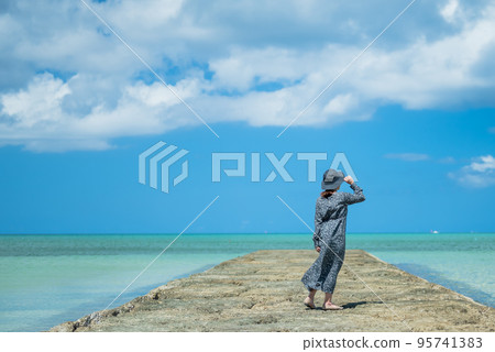 [Okinawa Central] A woman looking far away in the beautiful tropical sea ② 95741383
