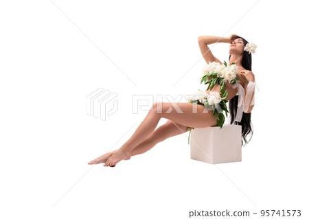 Sensual young woman with flowers on naked body sitting on cube isolated 95741573