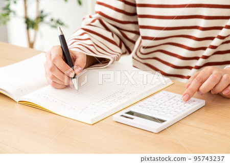 A middle-aged woman in a casual appearance with a household account book 95743237