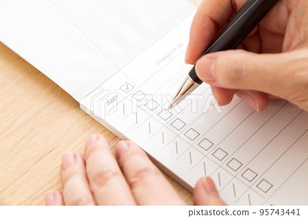 Middle woman's hand to sign the checklist 95743441