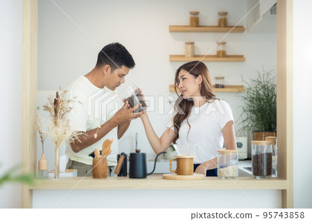 Couple to make, brew or drink coffee in kitchen home. Couple to make, brew or drink coffee in kitchen home. 95743858