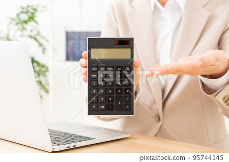 A middle-aged woman in a suit with a calculator 95744145