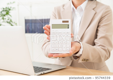 一位穿著西裝的中年婦女拿著計算器 95744339