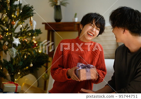 Girl receiving a Christmas present Close-up Girl receiving a Christmas present Close-up 95744751