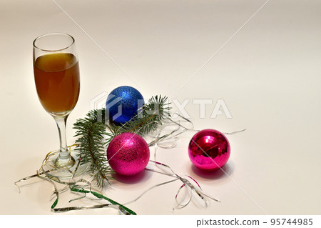 Glass balls decoration for the Christmas tree and a glass of wine. 95744985