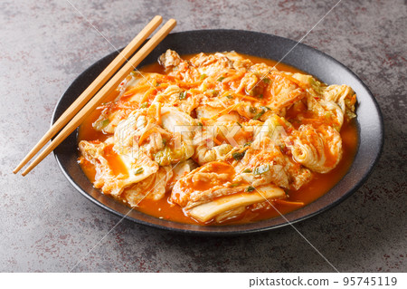 Kimchi is a traditional Korean side dish of salted and fermented vegetables, such as napa cabbage, carrot and Korean radish with spices closeup on the plate. Horizontal Kimchi is a traditional Korean side dish of salted and fermented vegetables, such as napa cabbage, carrot and Korean radish with spices closeup on the plate. Horizontal 95745119