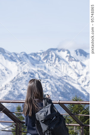A woman overlooking the scenery of the Hotaka mountain range A woman overlooking the scenery of the Hotaka mountain range 95748865